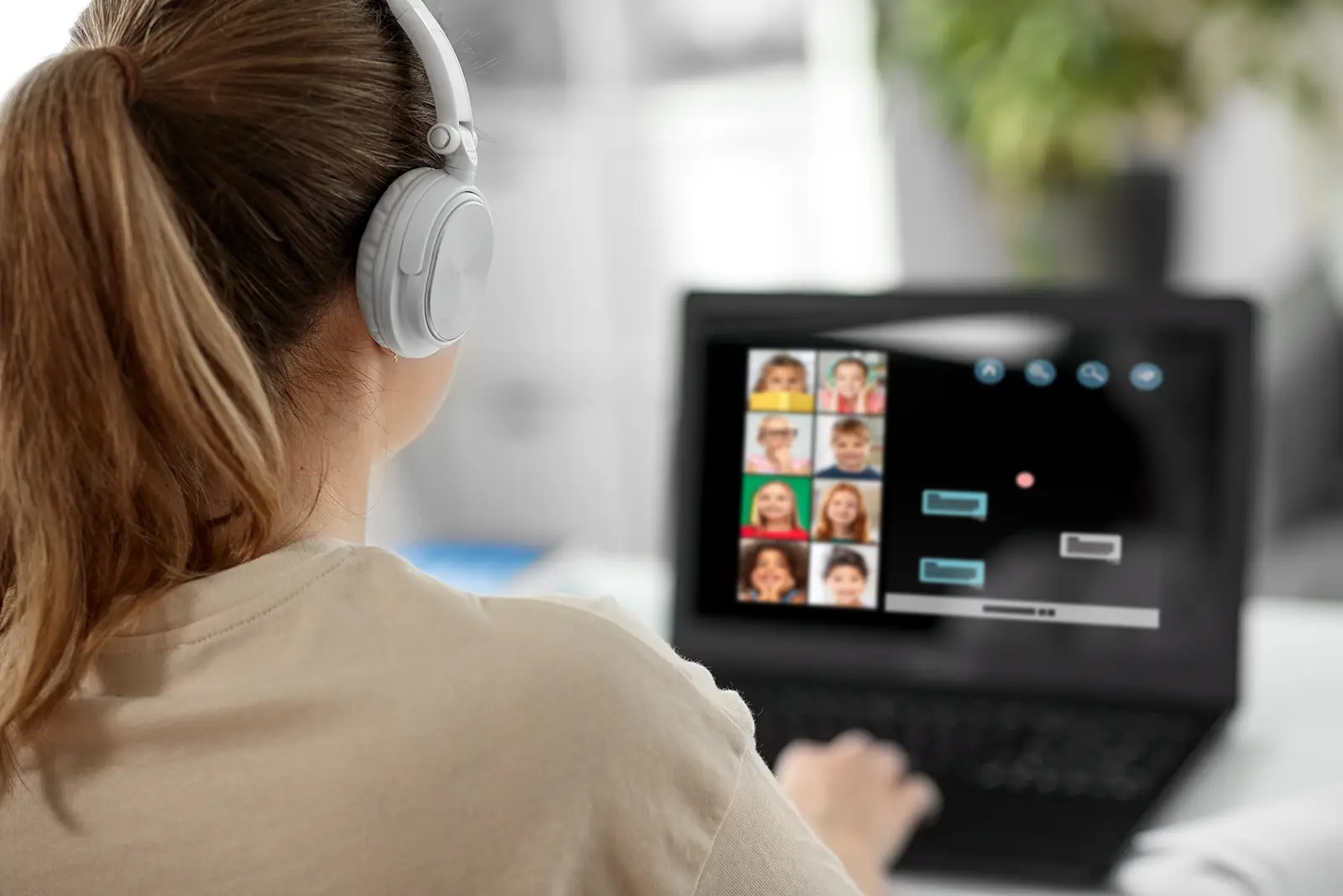 Student with headphones actively participating in a virtual language class with diverse young students on screen.